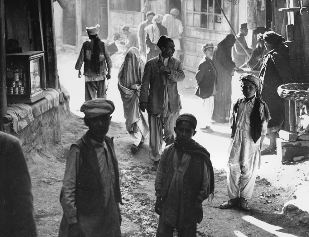 Afghan boys, men, and a woman walk through a street in Kabul, Afghanistan, on March 26, 1954.
