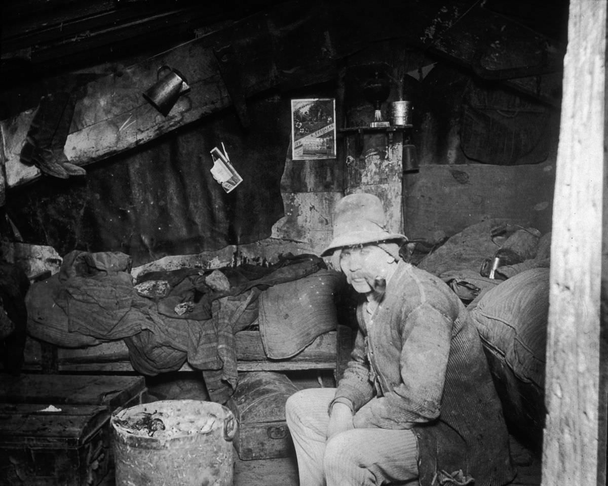 An Italian immigrant man smokes a pipe in his makeshift home under the Rivington Street Dump, 1890