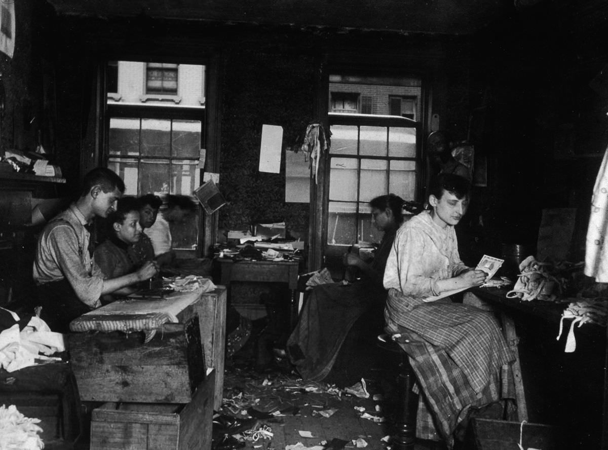 Men and women make neckties inside a tenement on Division Street in Little Italy, 1890