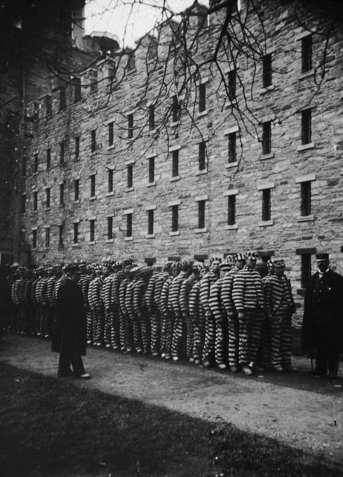 A group of prisoners are lined up at the Lock-step Penitentiary on Blackwell's Island (now Roosevelt Island), 1890