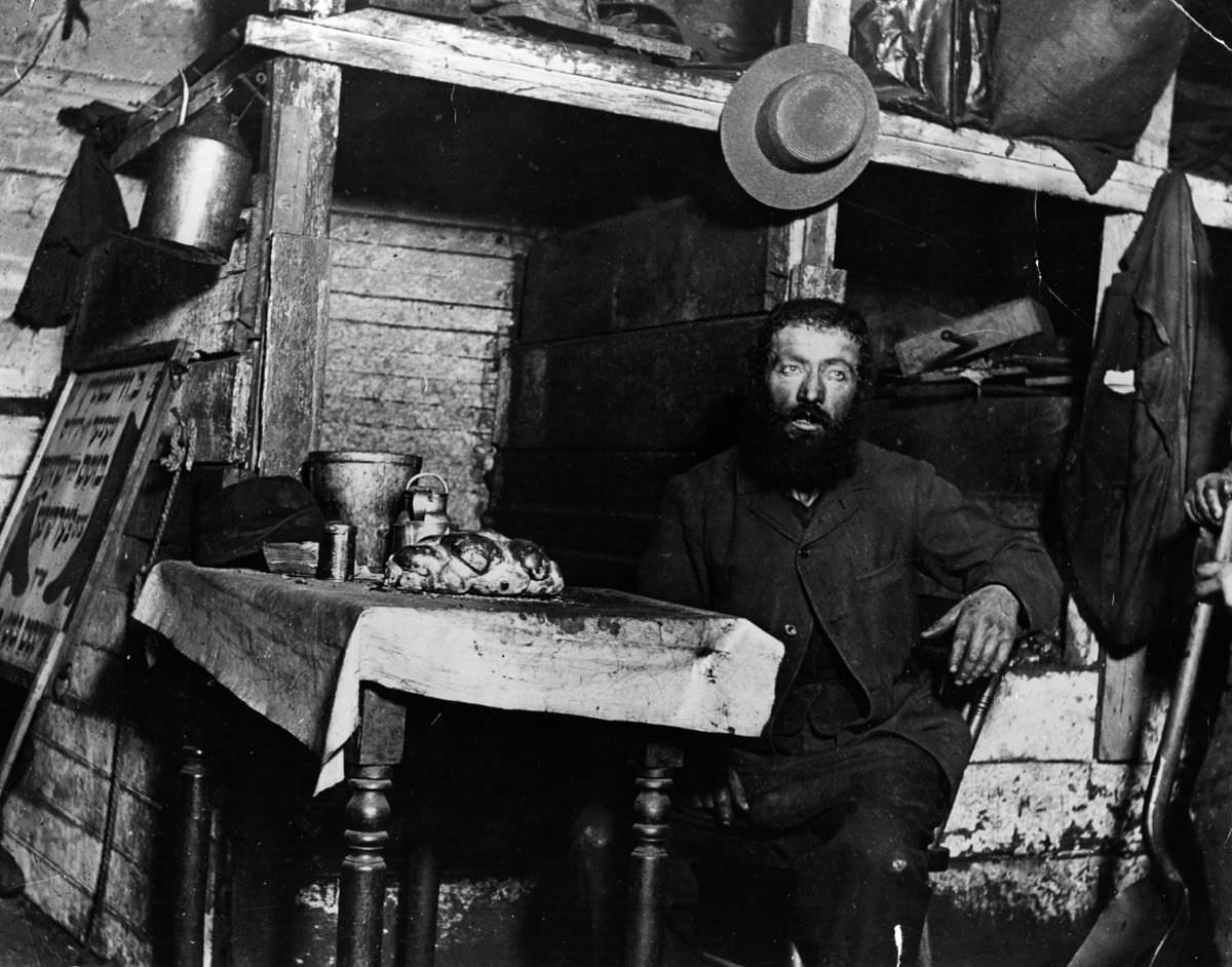 A Jewish cobbler ready for Sabbath Eve in a coal cellar where he lives with his family, 1887