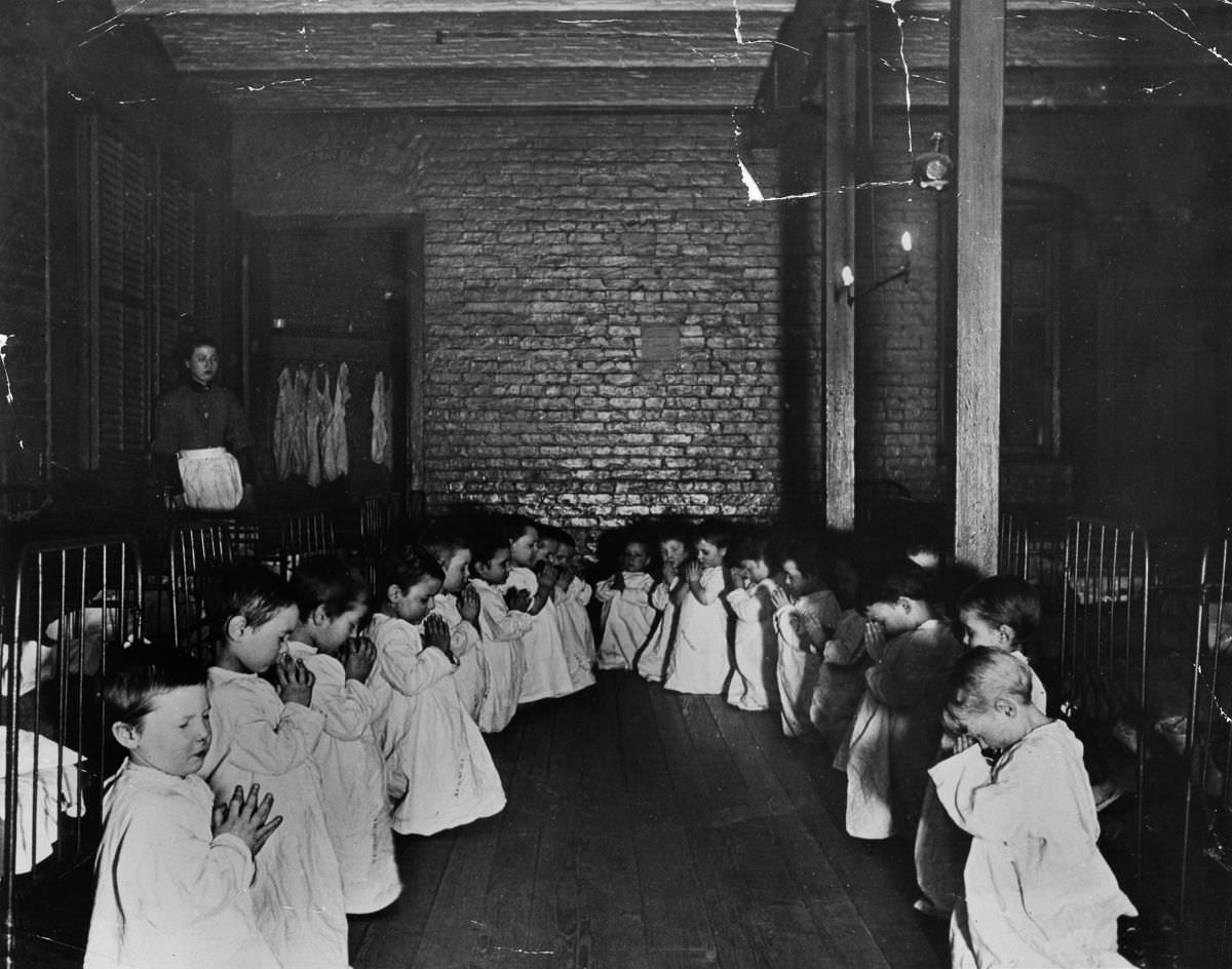 Children pray in the nursery in Five Points House, 1887