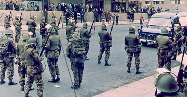 British troops straddle a main road near the Catholic Unity flats in Belfast, Northern Ireland