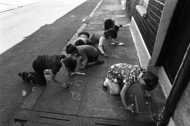 Children drawing pro Irish Republican Army notes with chalk on the pavement, such as Up the IRA, in Leeson Street in Belfast, Northern Ireland on August 17, 1971.