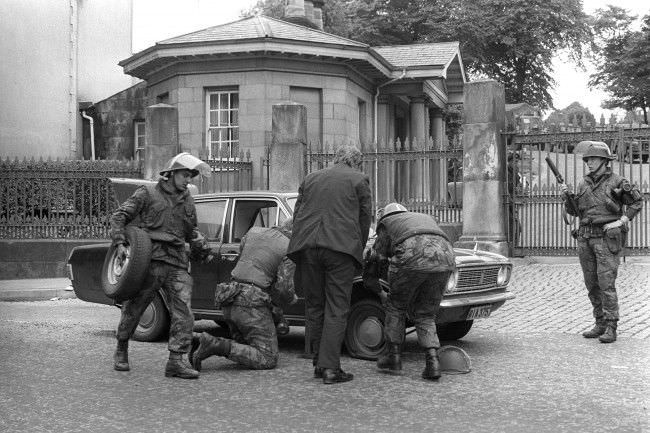 Soldiers changing a flat tyre on a car outside an Army base in Londonderry.