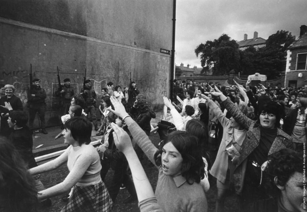 A crowd of demonstrators passing British soldiers in Leeson St. in the Falls Road area of Belfast, July 1970.