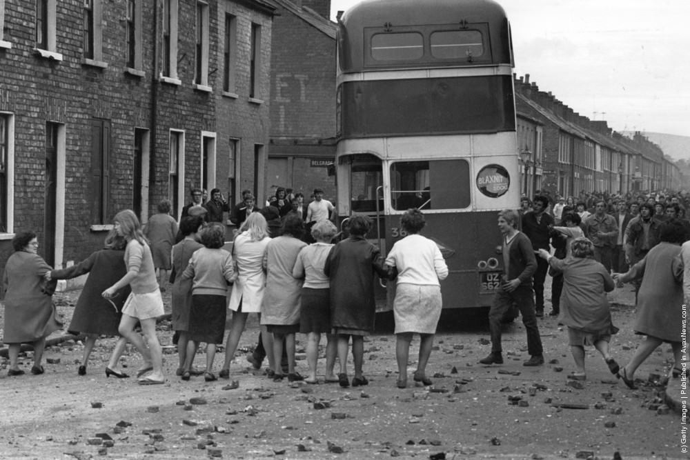 A commandeered bus is driven backwards through a picket of women who want the violence to end during riots on the Falls Road, Belfast, 3rd July 1970.
