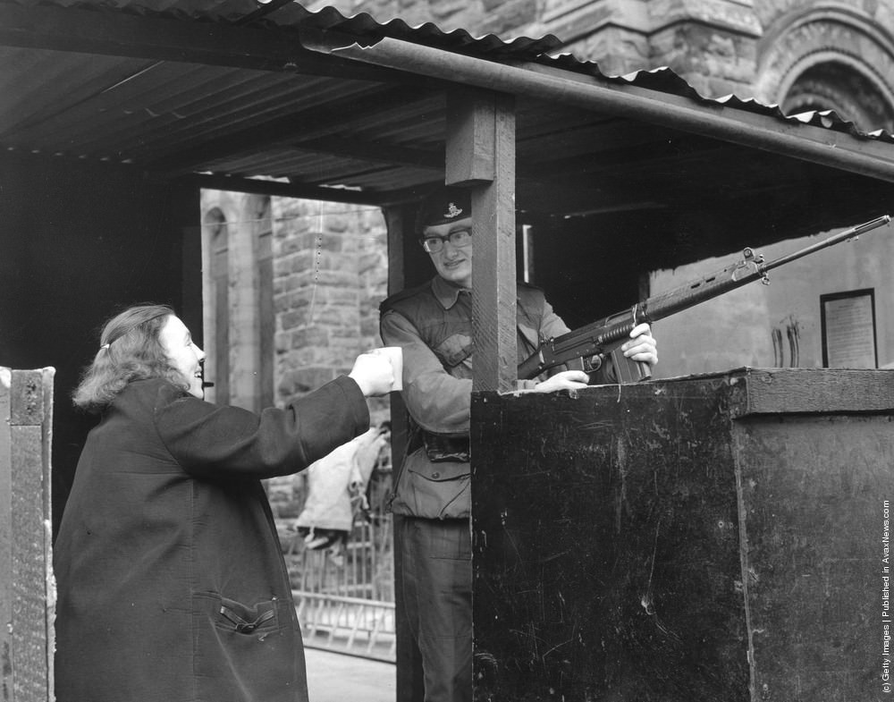 A woman offers a cup of tea to a soldier manning a check point in a Belfast street, 20th April 1971.
