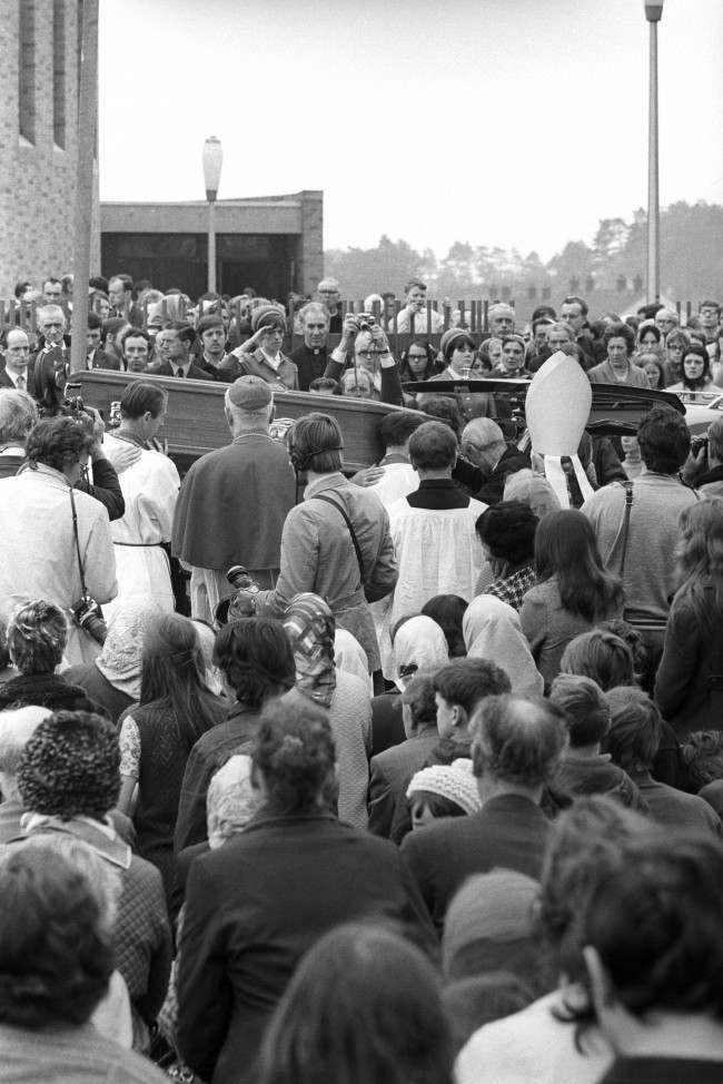 People of Ballymurphy estate pay their respects to Reverend Hugh Mullan as his coffin leaves Corpus Christi Roman Catholic Church after Requiem Mass.