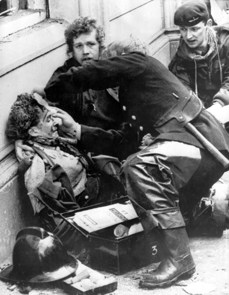 Firemen tend to a wounded victim of an Irish Republican Army car bomb explosion in Donegal Street, Belfast. The blast killed 6 people and injured 146, 1972.