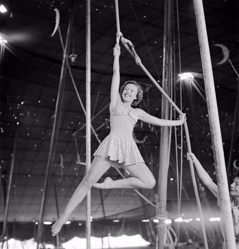 An aerialist rehearsing for the Ringling Bros. and Barnum & Bailey Circus while a circus girl is holding a rope in Sarasota, FL in 1949.