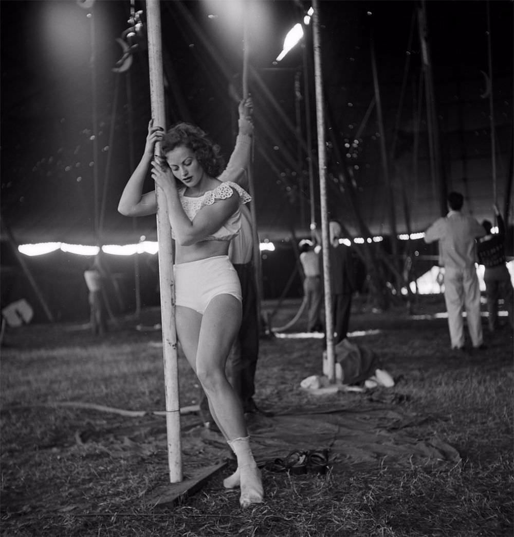 A circus girl standing near a pole while an unidentified man is holding a rope during a rehearsal for the Ringling Bros. and Barnum & Bailey Circus in Sarasota, FL in 1949.