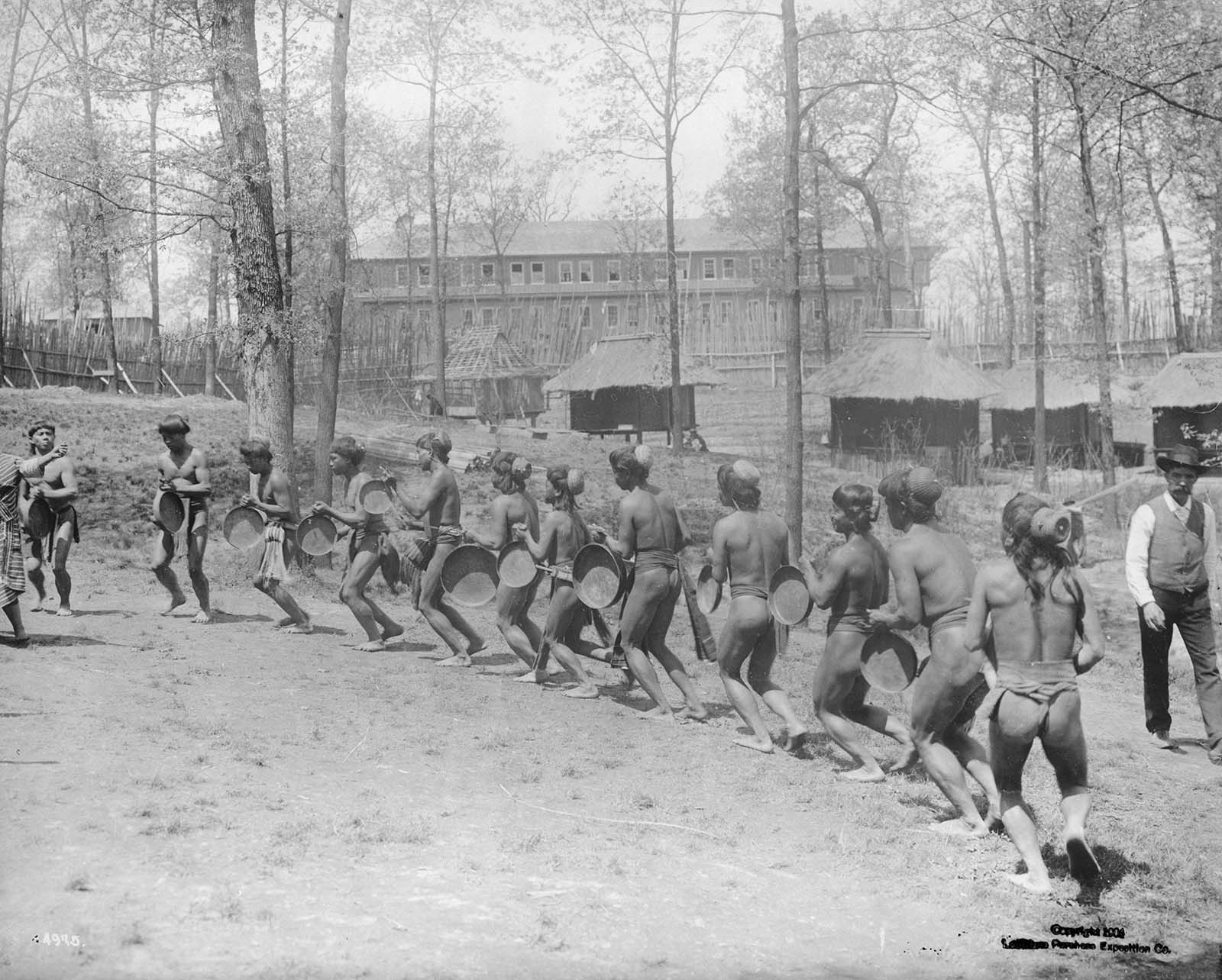 Igorot men from the Philippines wearing loincloths and carrying hand drums, dance at the Louisiana Purchase Exposition, November 13, 1904.