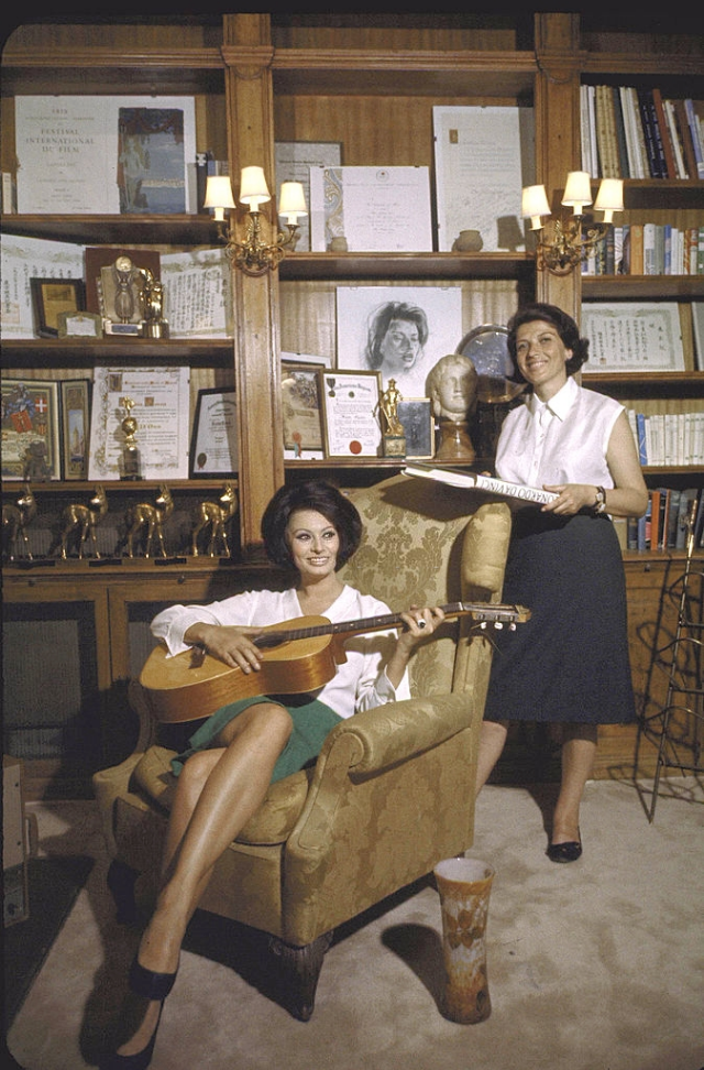 Sophia Loren holidng guitar, in her study with her faithful secretary Ines Bruscia.