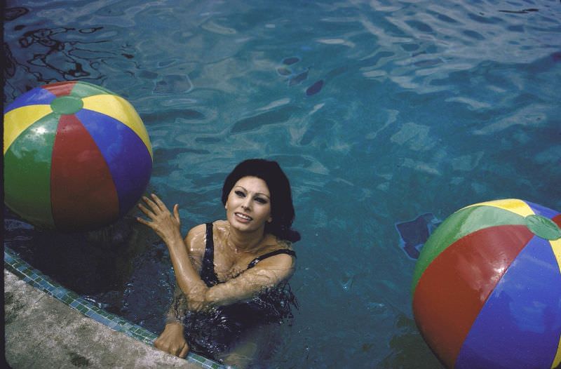 Sophia Loren in the pool with colorful beach balls.