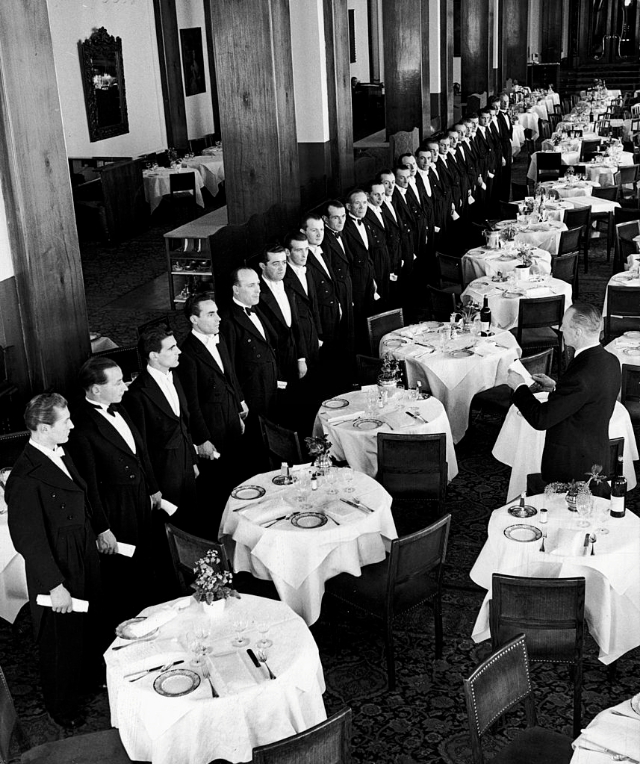 Headwaiter at the Palace Hotel in fashionable winter resort inspecting his wait staff.