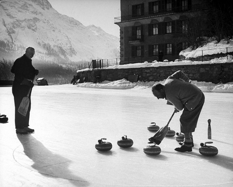 Men curling on frozen pond.