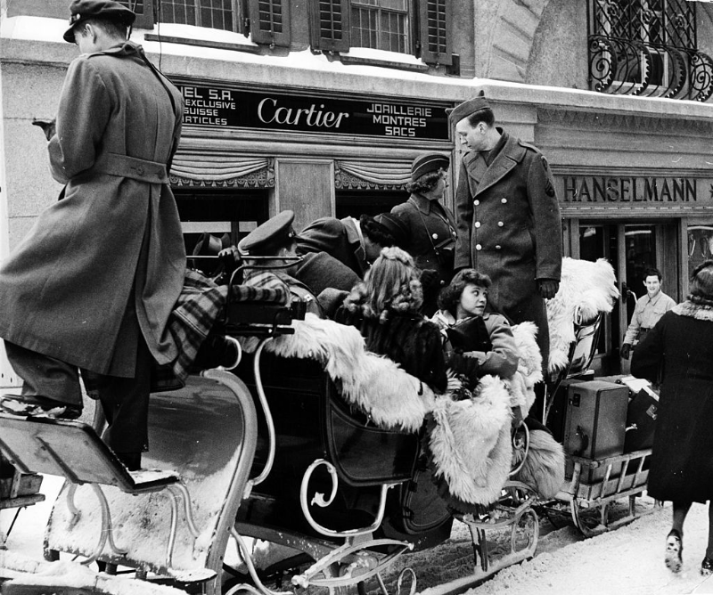 GIs on leave from Germany hiring sleigh to go from station to hotel in snow-covered winter-resort village.