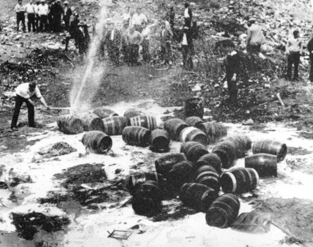 Beer barrels are destroyed by prohibition agents in an unknown location. Picture date: Jan. 16, 1920.