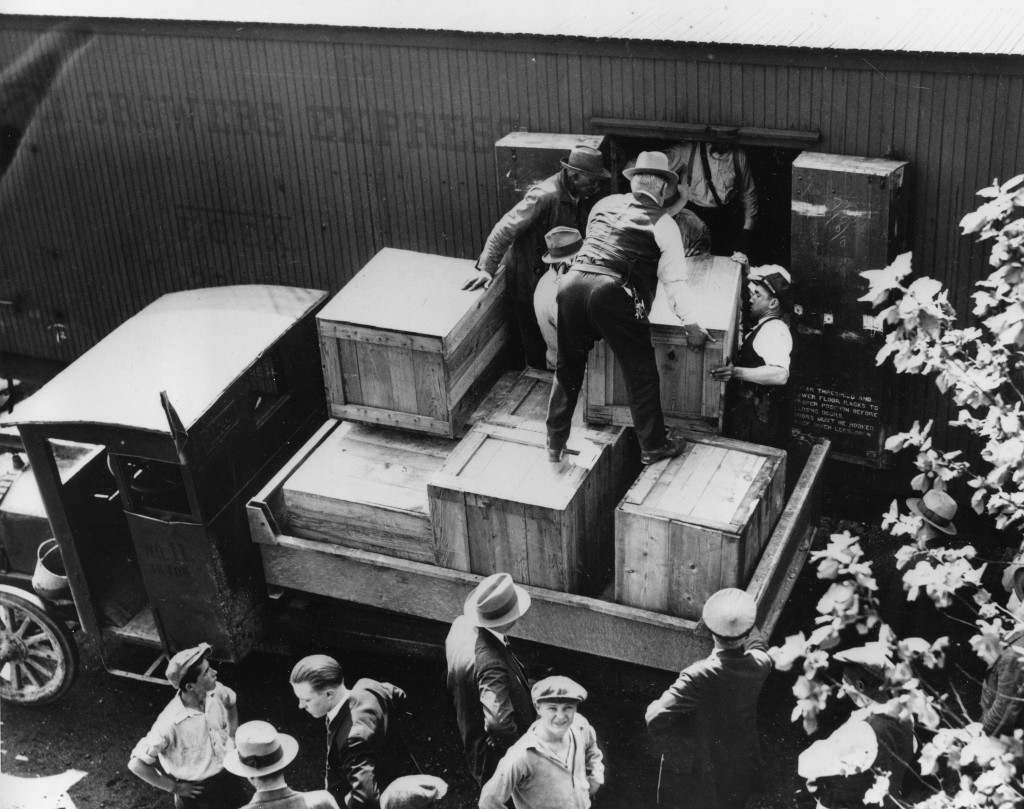 Authorities unload cases of whiskey crates labeled as green tomatoes from a refrigerator car in the Washington yards on May 15, 1929.