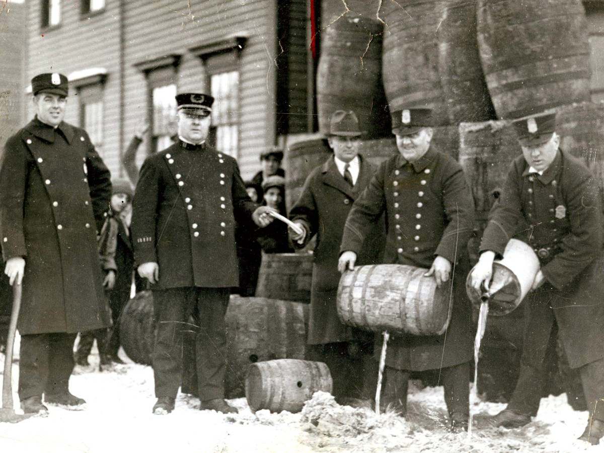 Officers in Cambridge, Massachusetts pour confiscated liquor into the sewer.