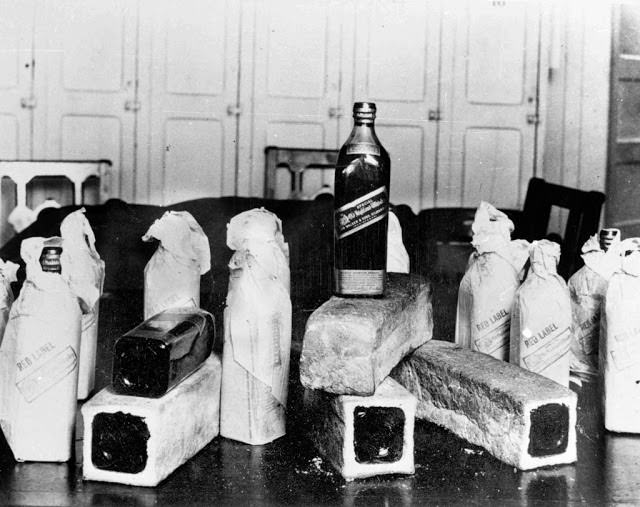 Bottles of Scotch whisky smuggled in hollowed-out loaves of bread are confiscated by police on June 12, 1924.