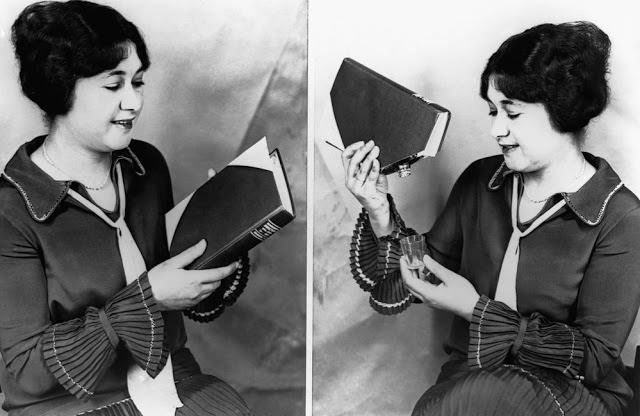 A woman demonstrates the use of a Prohibition era book that conceals a liquor flask, 1927.