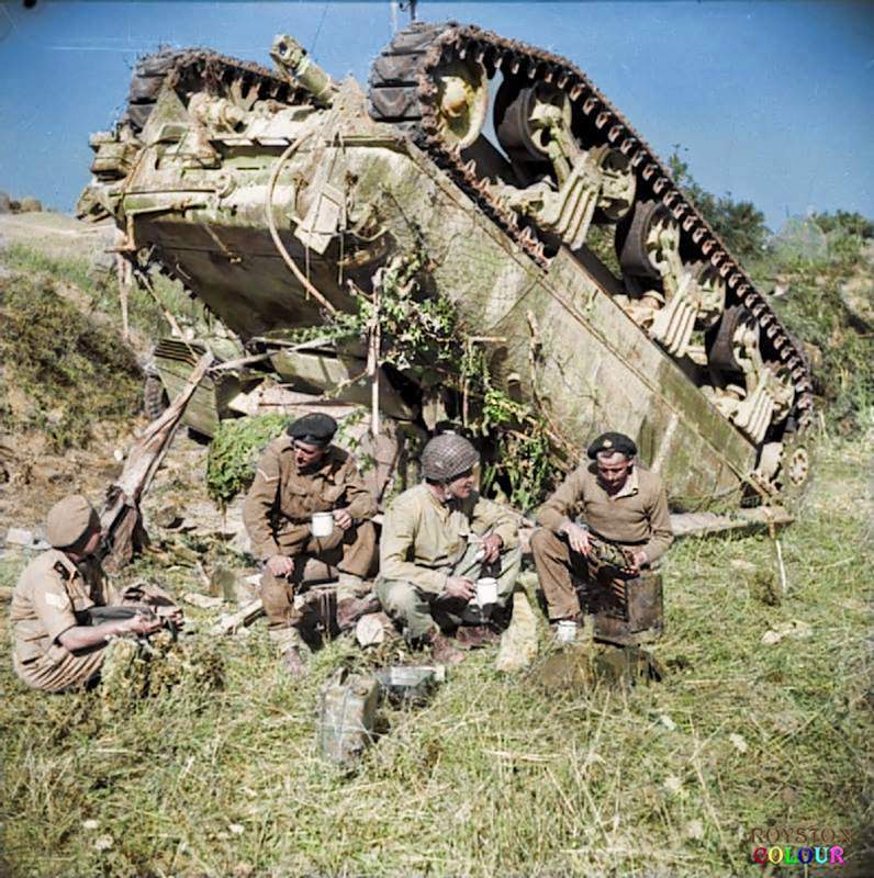 The crew of an up-ended (M4A1) Sherman tank of the 7th Armoured Brigade enjoy a ‘brew’ beside their vehicle while waiting for a recovery team, on the 'Gothic Line' in Italy, 13th of September 1944.