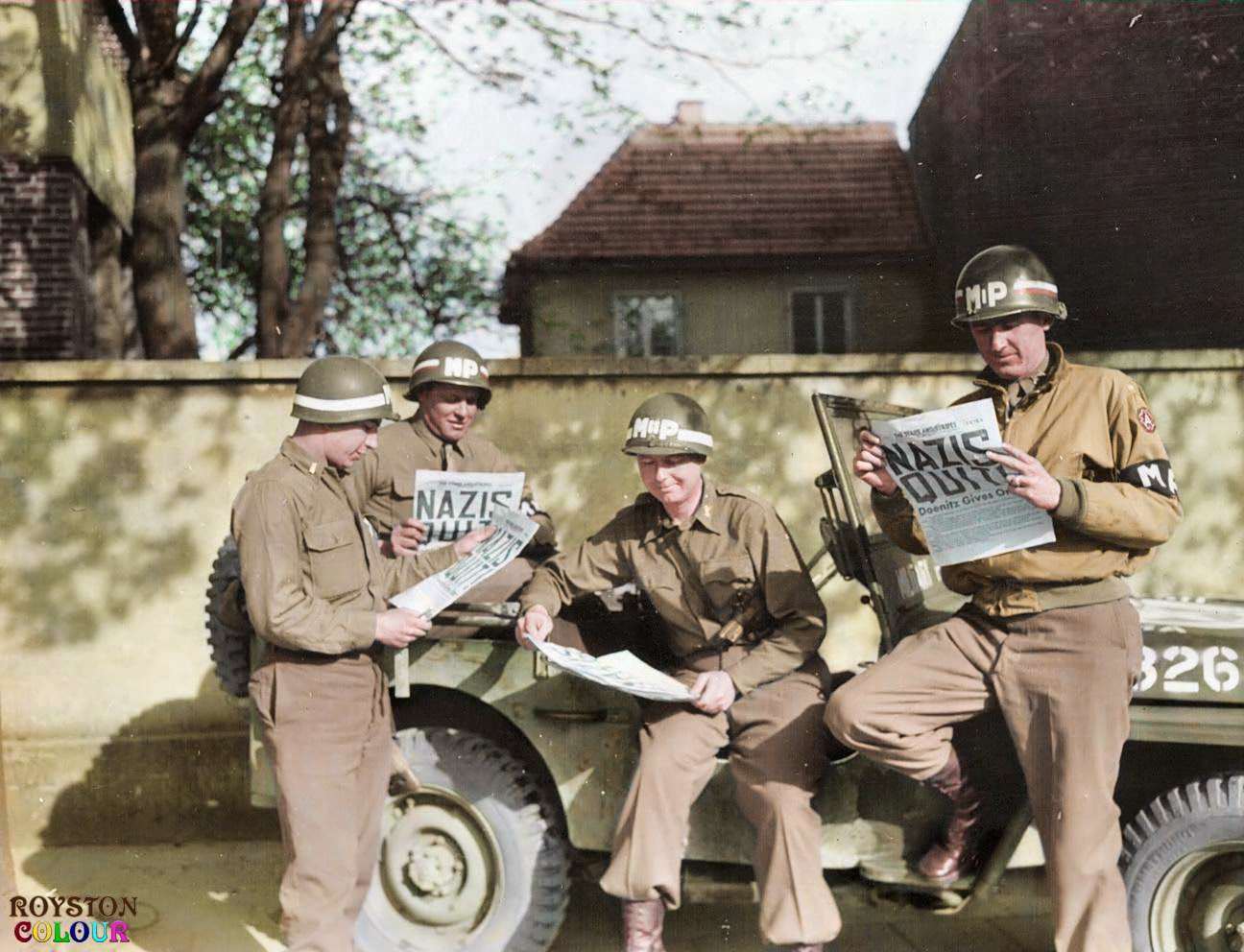 9th Army MPs reading of the surrender in the 'Stars and Stripes' in Germany on the 8th of May 1945
