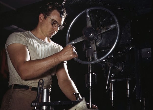 An employee in the drill-press section of North American’s huge machine shop runs mounting holes in a large dural casting, in Inglewood, California, in October of 1942