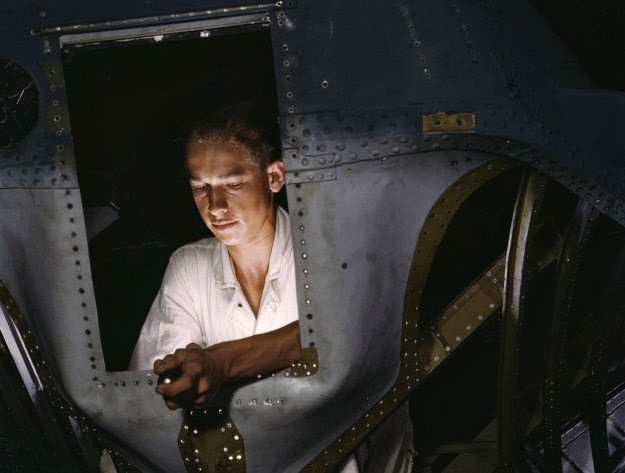 As an NYA (National Youth Administration) trainee working inside the nose of a PBY, Elmer J. Pace is learning the construction of Navy planes, at Corpus Christi Naval Air Base, in Texas, in August of 1942
