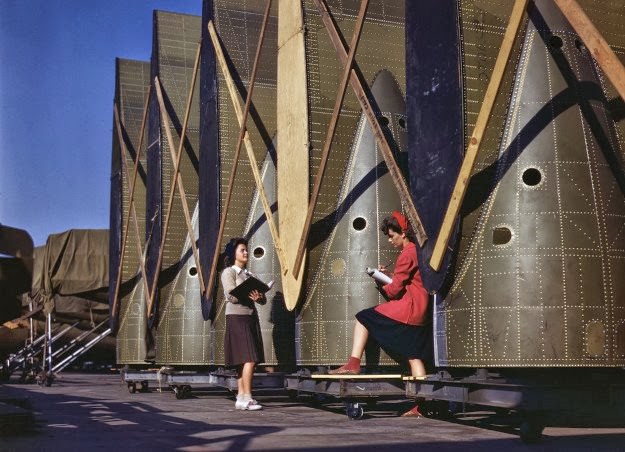 Carefully trained women inspectors check and inspect cargo transport innerwings before they are assembled on the fuselage, at Douglas Aircraft Company in Long Beach, California, in October of 1942