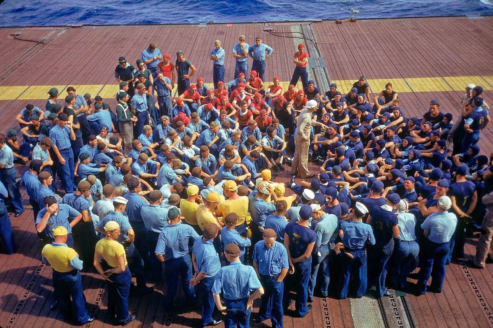 Crew aboard the aircraft carrier Enterprise CV-6 listening to instructions during the US Navy's Pacific Fleet maneuvers around Hawaii in 1940.