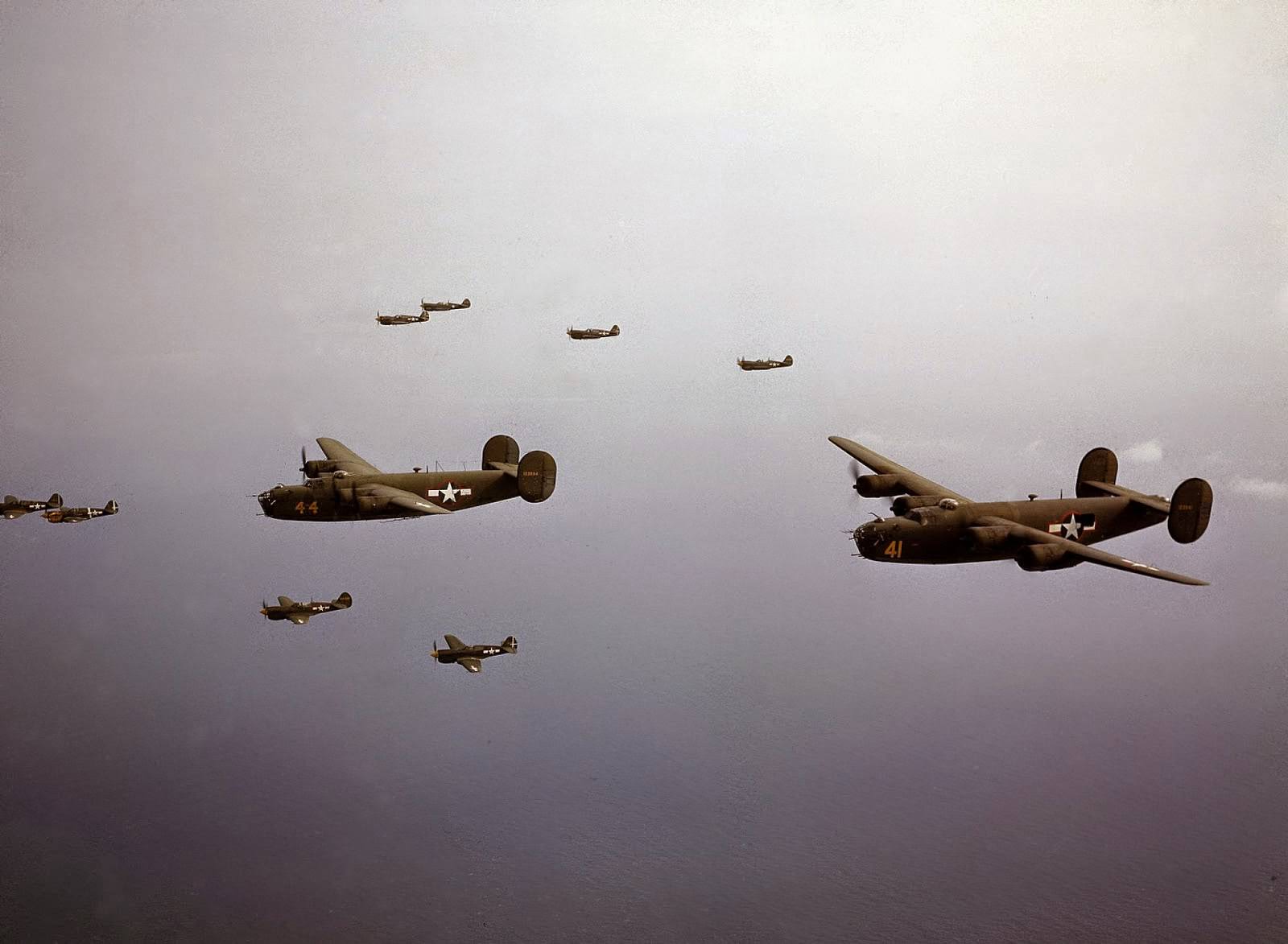 A group of Curtiss P-40 Warhawks escorted a pair of Consolidated B-24D Liberators on a flight near the Aleutian islands, Alaska, 1944.