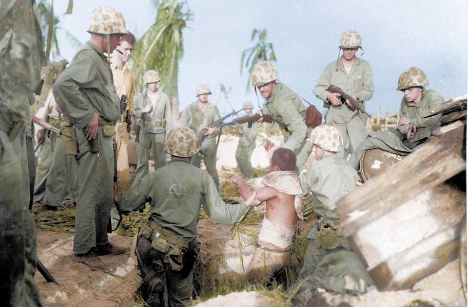 Captured wounded Japanese soldier surrounded by Marines on Kwajalein Atoll, Marshall Islands. During World War II, it's estimated that between 19,500 and 50,000 members of the Imperial Japanese military surrendered to the Allies.