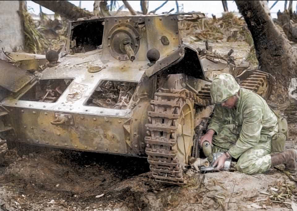 A U.S. Marine shares his water bottle with a stray kitten found under a burned-out Japanese tank on Tarawa in 1943.