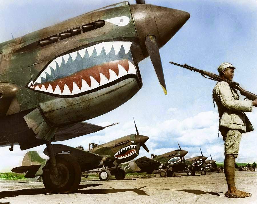 A Chinese Nationalist soldier guards a row of Curtiss P-40 'Warhawks' flown by the 'Flying Tigers' of the American Volunteer Group (AVG). July, 1942.