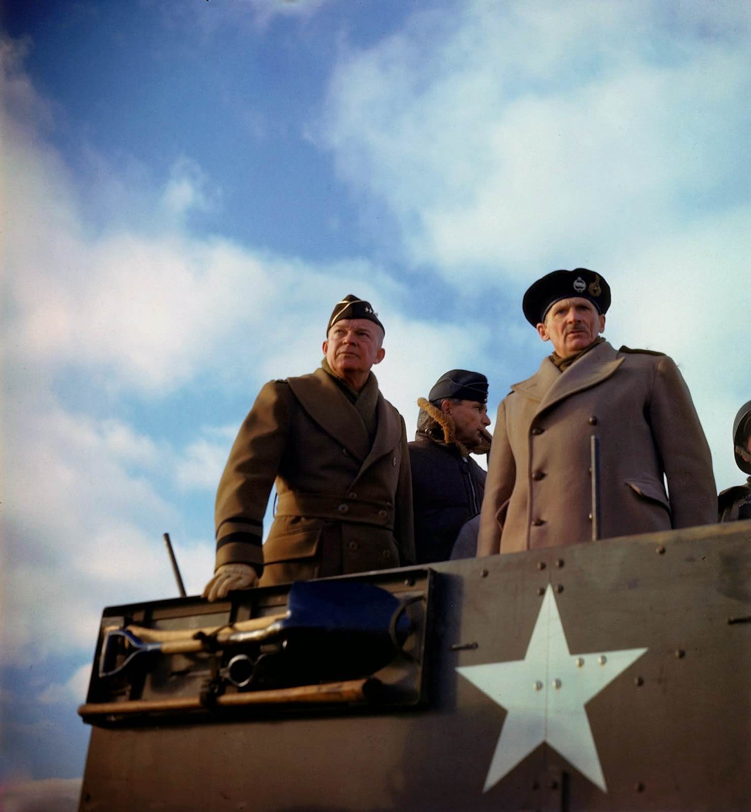Supreme Allied Commander American General Dwight D. Eisenhower, his deputy, British Chief Air Marshal Arthur Tedder , and the principal commander of Allied ground forces in Europe, British General Bernard L. Montgomery, stand in a US armored vehicle as they review a tank exercise, Salisbury, England
