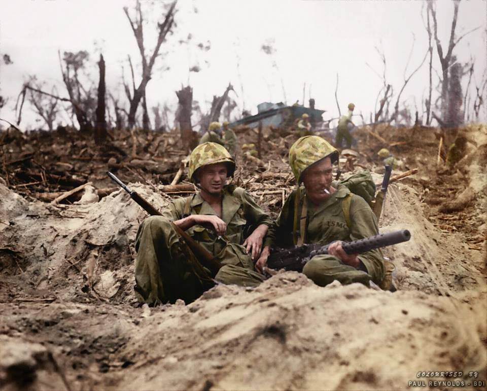 Marine Pfc. Douglas Lightheart (right) cradles his .30 caliber M1919 Browning machine gun in his lap, while he and Marine Pfc. Gerald Thursby Sr. take a cigarette break, during mopping up operations on Peleliu on 14th September 1944.