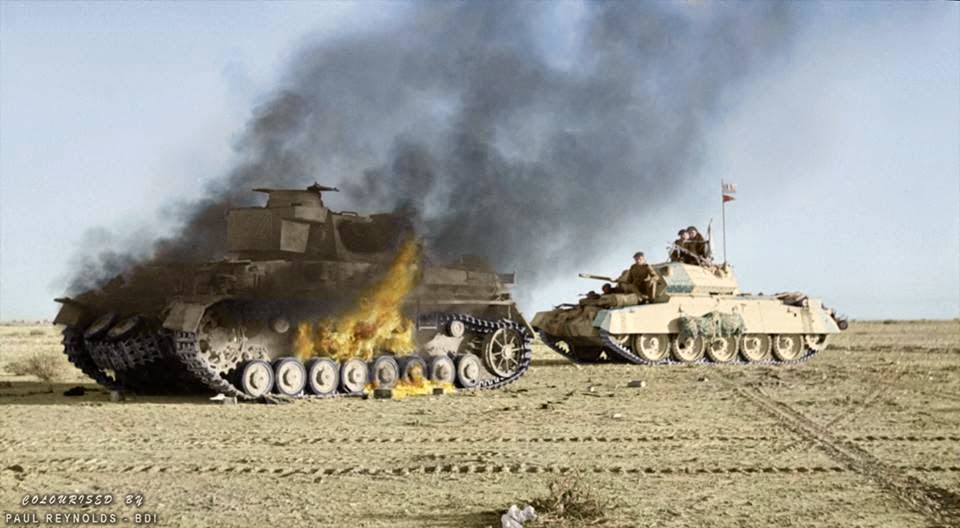A British Crusader tank passes a burning German Panzer IV tank during 'Operation Crusader'. Cyrenaica (the eastern province of Libya). Winter 1941