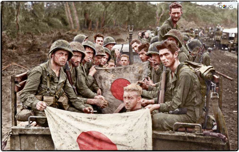 The strain and fatigue of 23 days on the line is shown by Marines of Combat Team 'C', 2/7th US Marines, 1st Marine Division seen here displaying Japanese battle flags captured during the Battle of Cape Gloucester. 14-15th January 1944