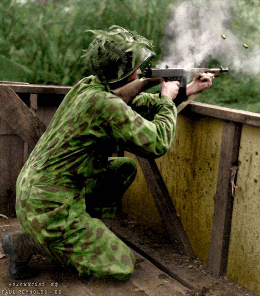 A US Marine wearing his camouflage suit fires a Thompson sub-machine gun during Jungle Training - 1942