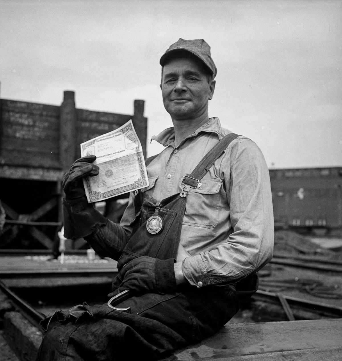 A shipyard worker shows off a war bond