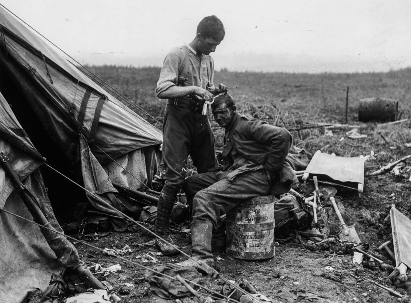A British soldier dresses the wounds of a German prisoner near Bernafay Wood. July 19, 1916.