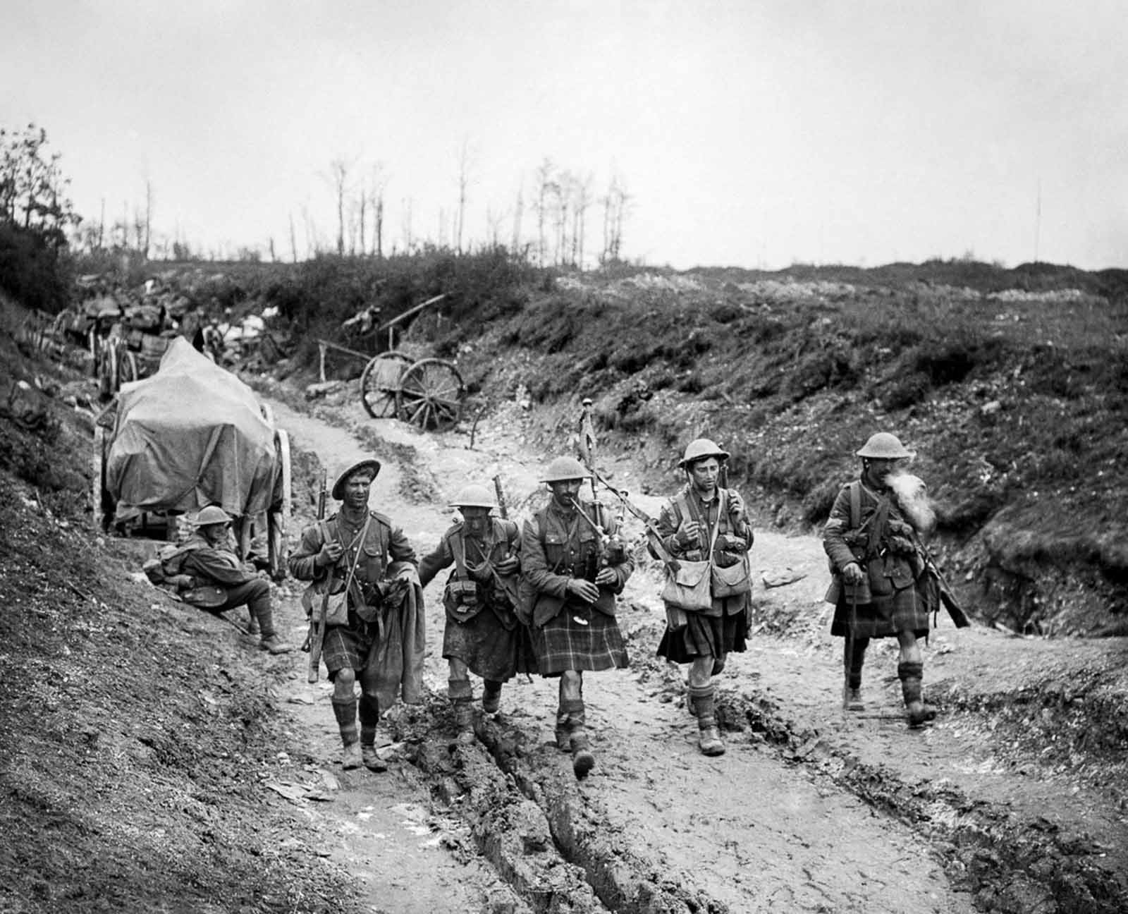 A piper of the 7th Seaforth Highlanders leads four men of the 26th Brigade back from the trenches after the attack on Longueval. July 14, 1916.