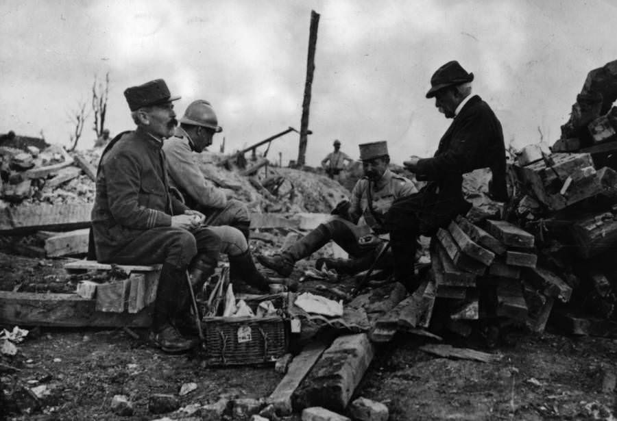 French statesman Georges Eugene Benjamin Clemenceau rests in a ruined village during a visit to the Somme front.