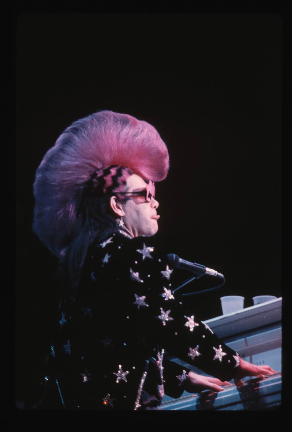 Elton John wearing Mackie costume, featuring a pink mohawk.