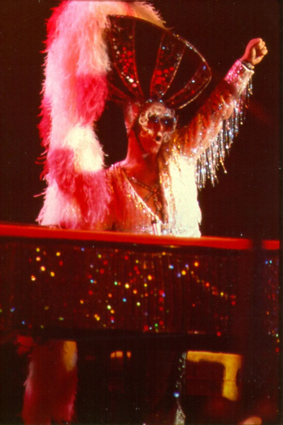 Elton John wearing a giant fuzzy hat, 1974