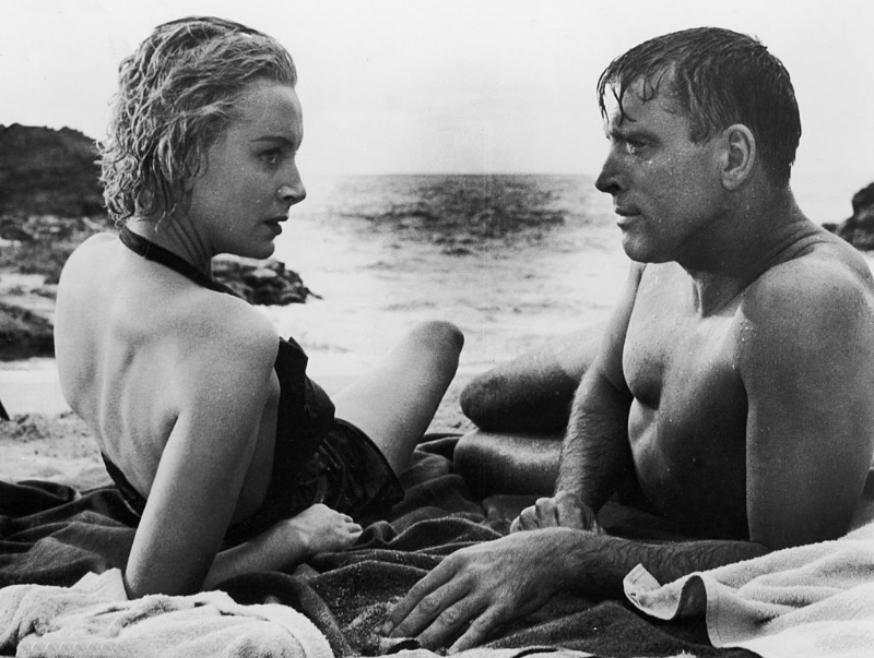 Deborah Kerr and Burt Lancaster lay on the beach in a still from the film 'From Here to Eternity,' 1953.