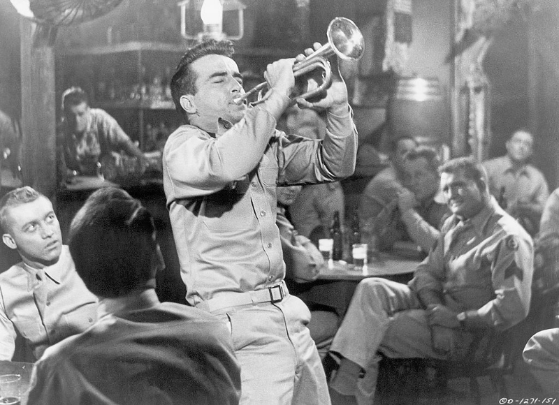 Montgomery Clift plays the trumpet in a bar during a scene from the film 'From Here to Eternity,' 1953.